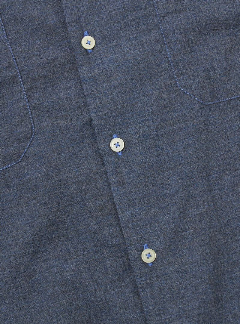 The Indigo Fine Organic Cotton Sal Road Shirt is shown from the back as a flat lay against a plain white background. The image highlights the shirt's straight hem, short sleeves, and the deep indigo color of the fine organic cotton fabric.