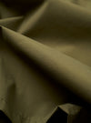A close-up fabric swatch of the Olive Recycled Polytech Z Tech Overshirt highlights the solid olive green color and the clean, compact texture of the technical recycled polyester and cotton blend.