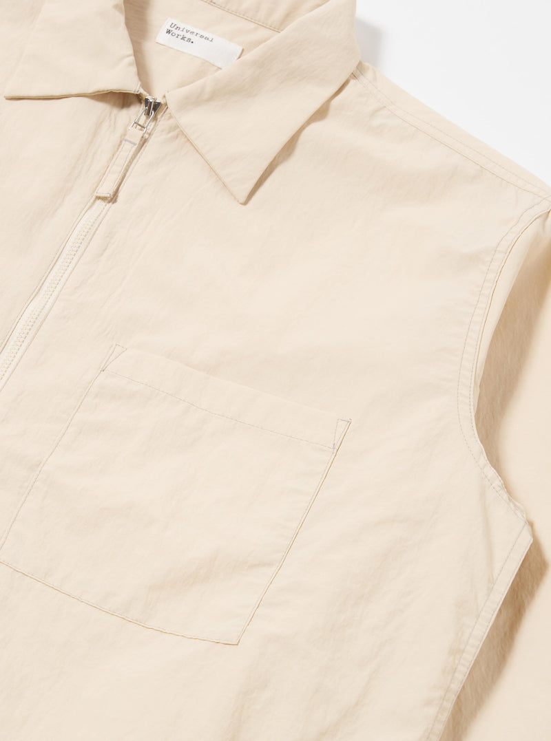 The Stone Seo Recycled Nylon Zip Too Shirt is shown in a detail view as a flat lay against a plain white background. The image highlights the smooth, technical texture of the stone-colored recycled nylon fabric and the construction of a chest patch pocket.
