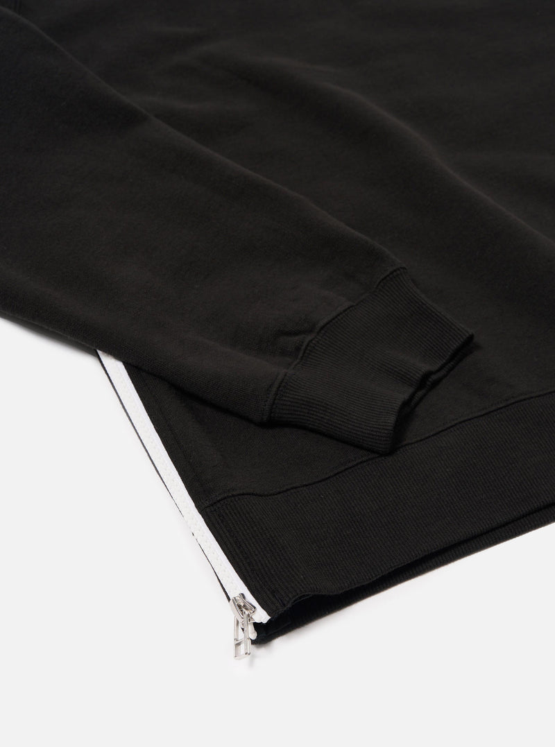 The Black Brush Back Sweat Billy Sweat is shown in a detail view as a flat lay against a plain white background. The image highlights the soft, brushed texture of the black cotton fabric and the ribbed detailing at the collar.