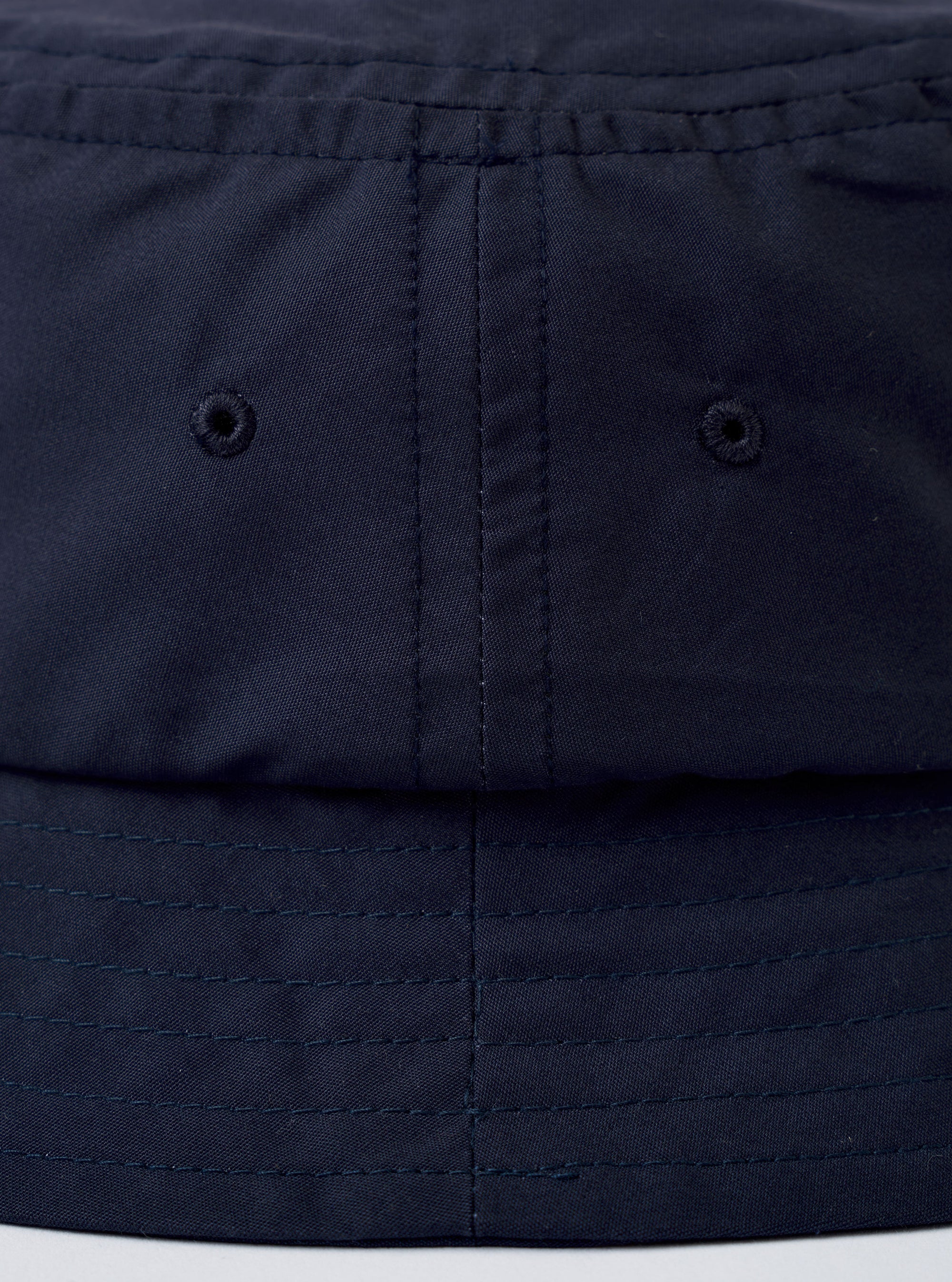 The Navy Recycled Polytech Beach Hat is shown as a flat lay against a plain white background. The hat features a classic bucket-style crown and a wide, downward-sloping brim with tonal circular stitching. The fabric has a smooth, technical appearance in a solid dark navy blue.