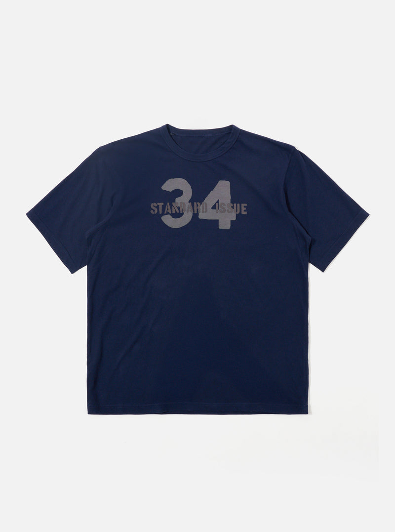 The Navy Single Jersey 34 Printed Core Tee is shown as a flat lay against a plain white background. The short-sleeve t-shirt features a ribbed crew neck and a prominent graphic print on the chest. The garment is constructed from a dark navy cotton jersey fabric with a smooth finish.