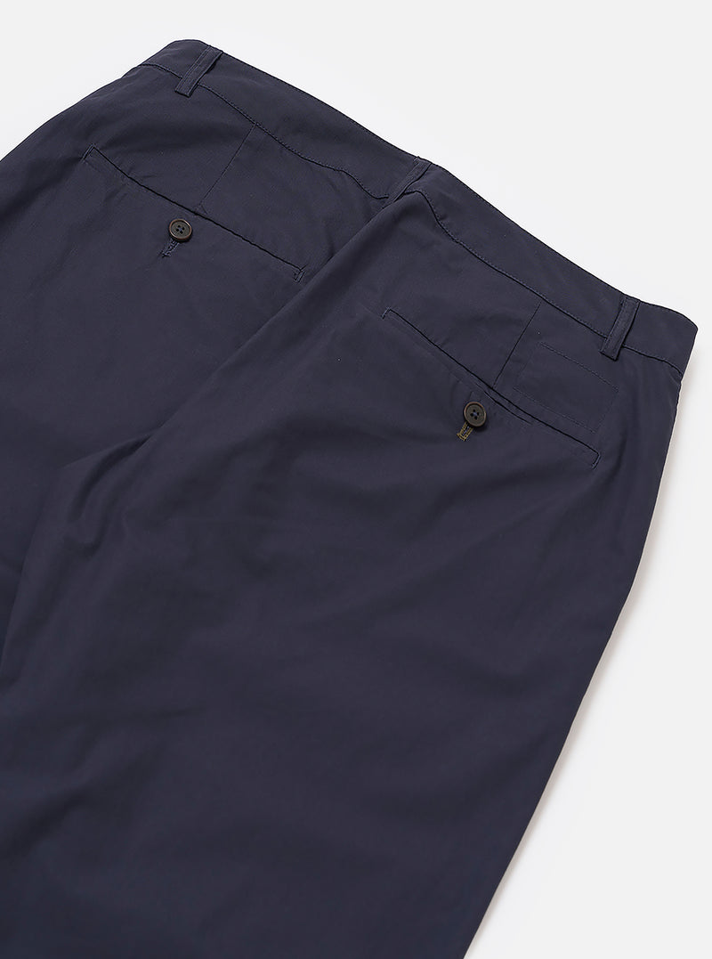 The Navy Peached Poplin Military Chino is shown in a detail view as a flat lay against a plain white background. The image highlights the two rear jetted pockets with button closures and the clean stitching of the back rise. The navy blue cotton fabric has a soft, matte peached finish.