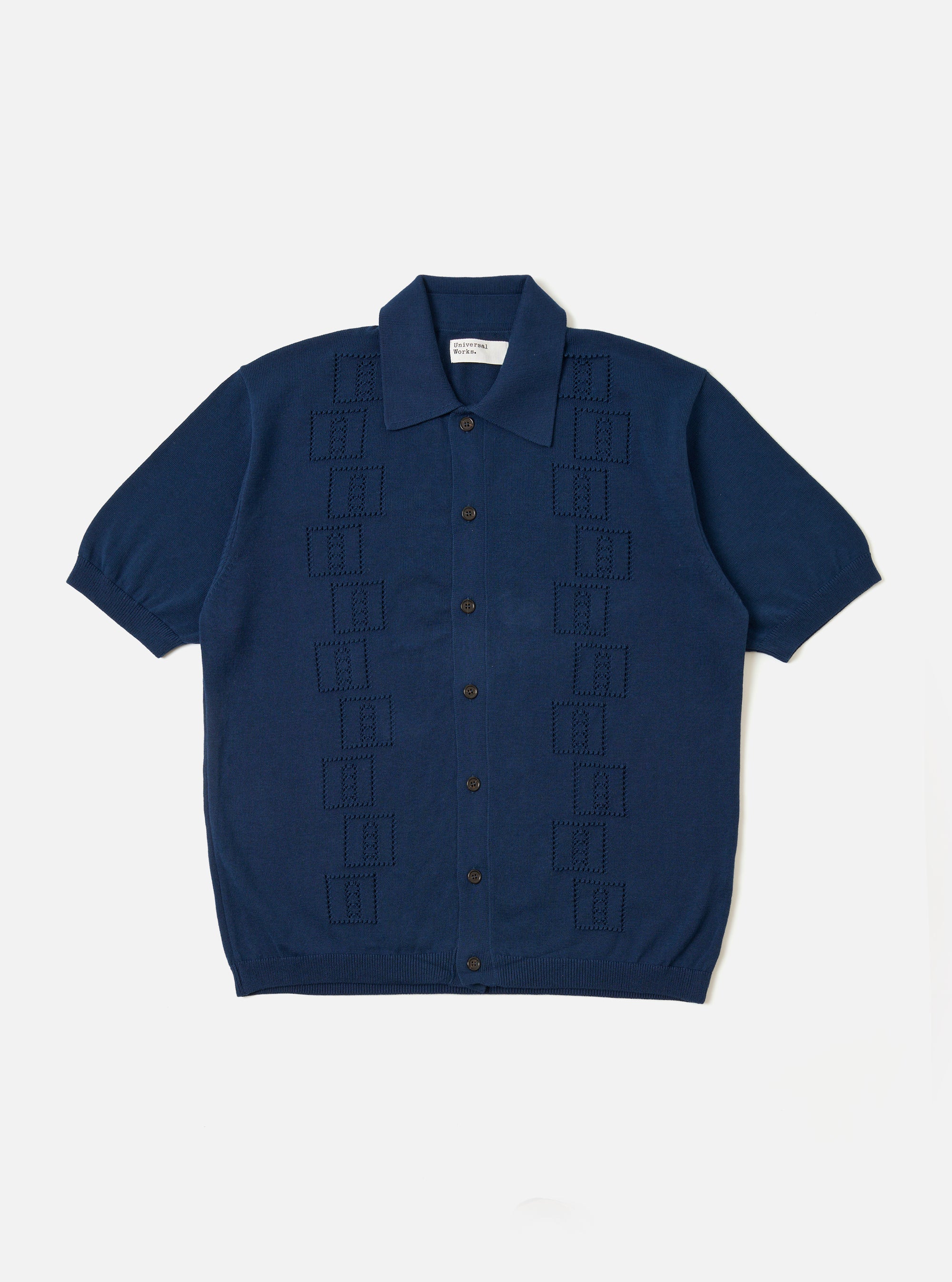 The Dark Navy Cotton Lace Knit Jonny Knit Shirt is shown as a flat lay against a white background. The shirt features a full-button front, a classic pointed collar, and short sleeves. The garment is characterized by its intricate, open-work lace knit texture in a deep navy blue.