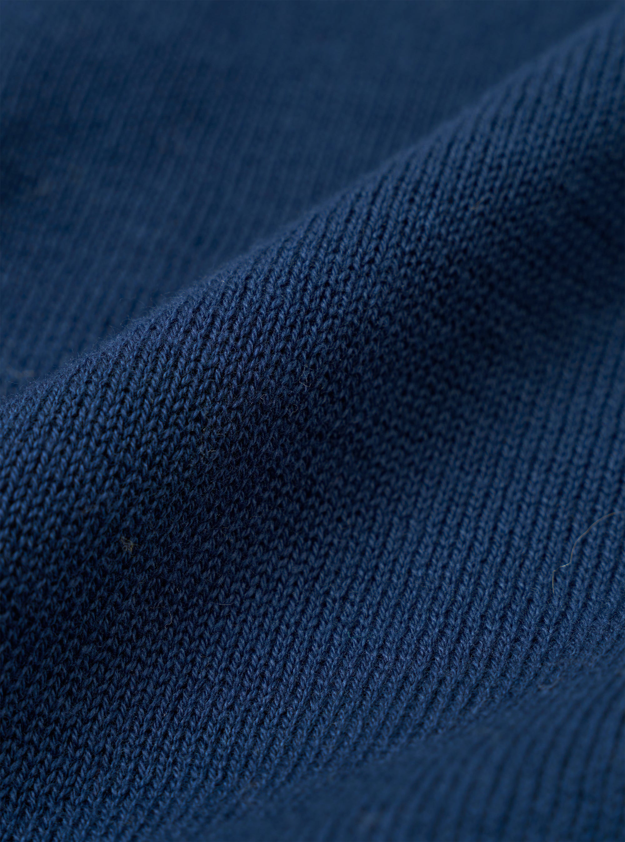 A close-up swatch image of the Dark Navy Cotton Lace Knit Jonny Knit Shirt highlights the intricate square-patterned, open-texture lace knit of the deep navy cotton fabric. The fabric fills the frame, showcasing the detailed texture and color of the material.