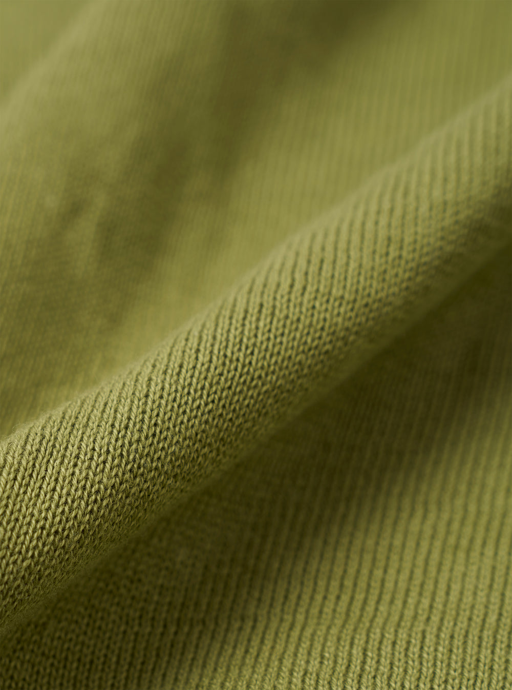 A close-up swatch image of the Olive Cotton Lace Knit Jonny Knit Shirt fabric. The image focuses on the olive green cotton material, highlighting its intricate open-work lace knit pattern and textured finish.