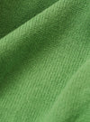 A close-up fabric swatch of the Green Eco Cotton Knit Pocket David Cardigan highlights the vibrant green color and the textured knit of the eco cotton material. The fabric fills the frame, providing a detailed view of the garment's weave and color.