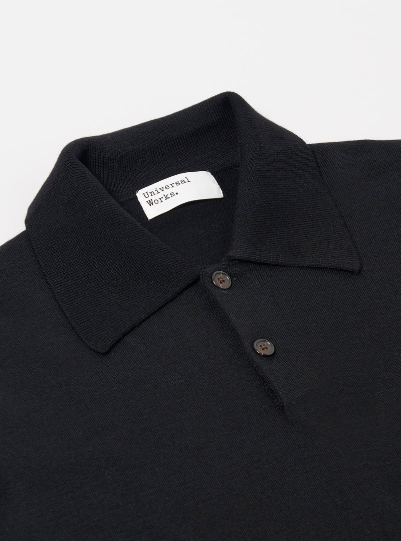 The Black Woolcot Bio S/S Pullover Knit Shirt II is shown from a rear angle as a flat lay against a plain white background. The image highlights the smooth, fine-gauge knit texture of the black fabric, the short sleeves, and the straight hem.