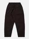 The Licorice Summer Canvas Pleated Track Pant is shown from a rear angle as a flat lay against a plain white background. The image highlights the single rear patch pocket with a buttoned flap and the elasticated waistband. The dark brown cotton canvas fabric features visible stitching details along the seams and hem.