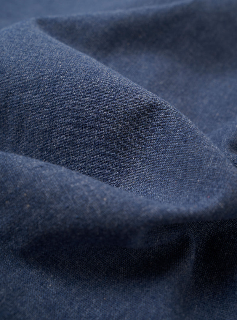 The Blue Sintra Recycled Cotton E130 Jacket is displayed as a flat lay against a plain white background. The jacket features a standard collar, a central button closure, and two large patch pockets at the waist. The fabric is a solid blue recycled cotton blend with a smooth texture.