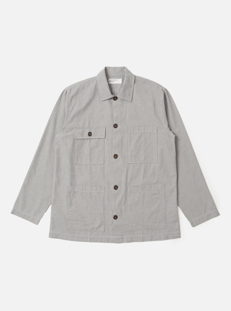 The Grey Izumi Cotton Dockside is shown as a flat lay against a plain white background. The overshirt features a classic collar, a central button-down front, and two large patch pockets at the waist. The grey cotton fabric has a fine, textured appearance.