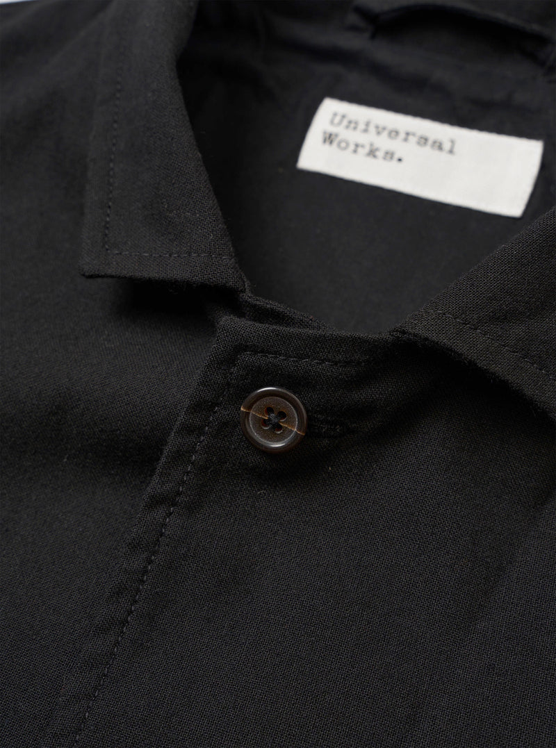 The Black Valencia Cotton Two Button Jacket is shown from the back as a flat lay against a plain white background. The image highlights the garment's rear construction, featuring a central vertical seam and a clean, straight hem. The black fabric appears smooth with a subtle technical finish.