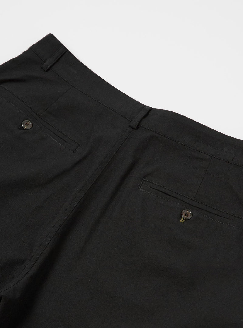 The Black Valencia Cotton Military Chino is shown from a rear angle as a flat lay against a plain white background. The image highlights the two rear patch pockets, one with a button-down flap, and the clean construction of the straight-leg design. The black fabric has a subtle, textured appearance.