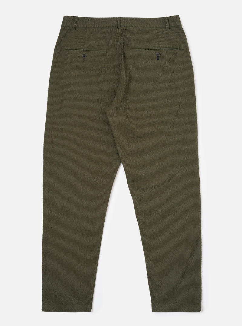 The Olive Merida Seersucker Military Chino is shown from the back as a flat lay against a plain white background. The image highlights the two rear pockets, including one with a button-down flap and one jetted, along with the elasticated portion of the waistband and the textured olive green seersucker fabric.