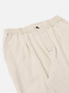 The Ecru Koko Cotlin Pleated Track Pant is shown from the back as a flat lay against a plain white background. The image highlights the elasticated waistband and two rear pockets, one with a buttoned flap and one jetted with a button. The ecru-colored fabric has a visible textured, slubby appearance.