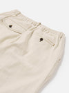 The Ecru Koko Cotlin Pleated Track Pant is shown from the back as a flat lay against a plain white background. The image highlights the elasticated waistband and two rear pockets, including one with a buttoned flap and one buttoned jetted pocket. The lightweight, textured ecru fabric is visible throughout.