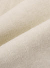 A close-up swatch image of the Ecru Koko Cotlin Pleated Track Pant fabric displays a light cream color with a visible textured weave characteristic of a cotton and linen blend. The material fills the frame, providing a detailed view of the textile's surface.