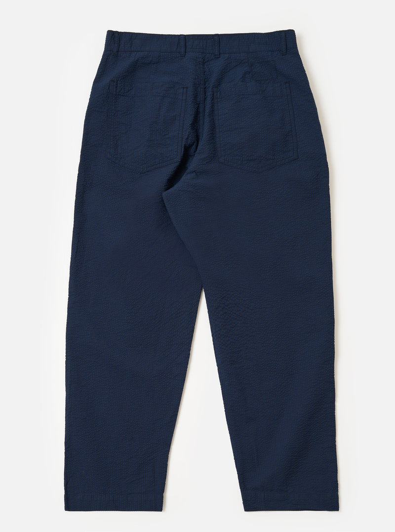 The Navy Derby Stripe Duke Pant is shown from the back as a flat lay against a plain white background. The trousers feature a loose, wide-leg fit and are made from a navy blue cotton fabric with thin, vertical white stripes. Visible details include a single rear patch pocket on the right side and a clean, straight hem.