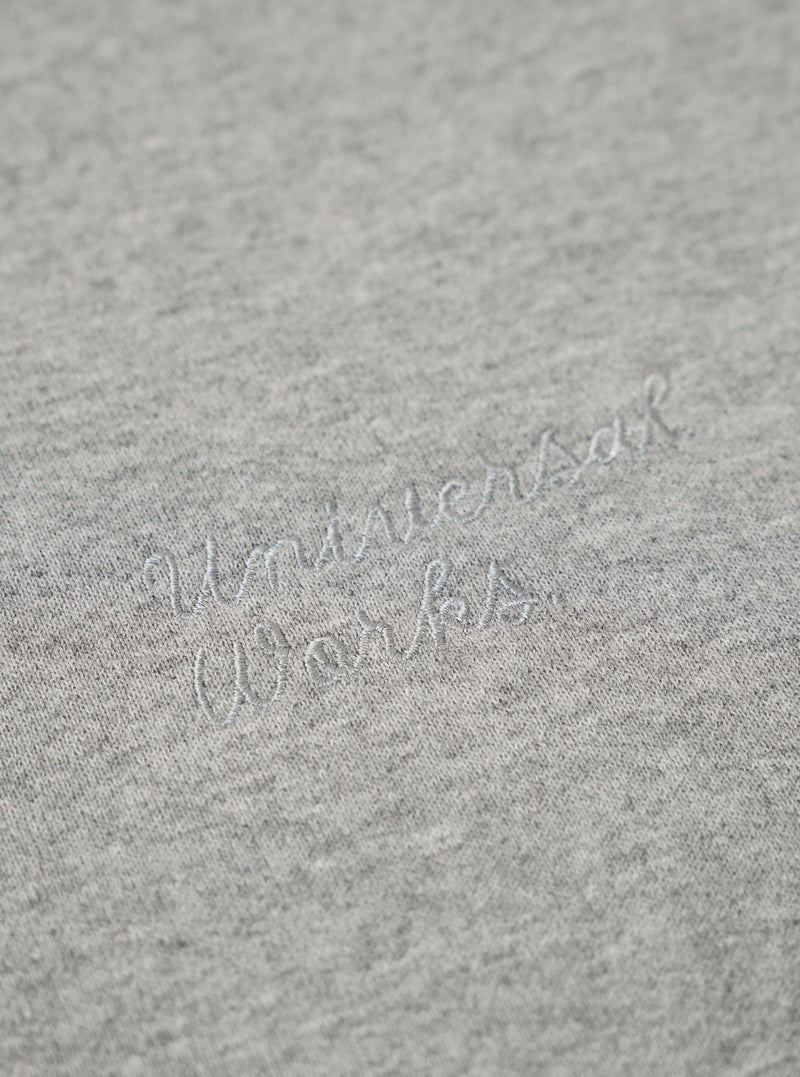 The Grey Marl Recycled Cotton Blend Jersey Loose Sweatshirt is shown from the back as a flat lay against a plain white background. The image highlights the sweatshirt's relaxed, loose fit, its simple crew neck, and the ribbed cuffs and hem. The fabric has a classic grey marl texture.