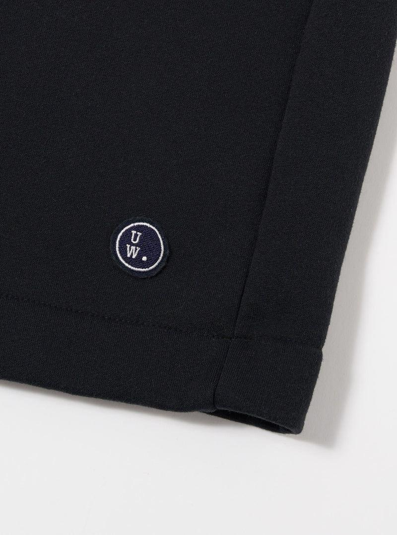 The Black Recycled Cotton Blend Jersey Vacation Short is shown from the back as a flat lay against a plain white background. The image highlights the elasticated waistband and a single rear patch pocket. The black jersey fabric has a soft, matte appearance with clean stitching along the hem and pocket.