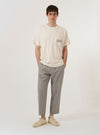 The Ecru Organic Jersey Print Pocket Tee is shown as a flat lay against a white background. The short-sleeve t-shirt is an off-white ecru color and features a crew neck and a single chest pocket on the left side with a graphic print detail.
