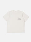 The Ecru Organic Jersey Print Pocket Tee is shown as a flat lay against a white background. The t-shirt features a crew neckline, short sleeves, and a single chest pocket on the left side with a graphic print. The fabric is a solid ecru organic cotton jersey.