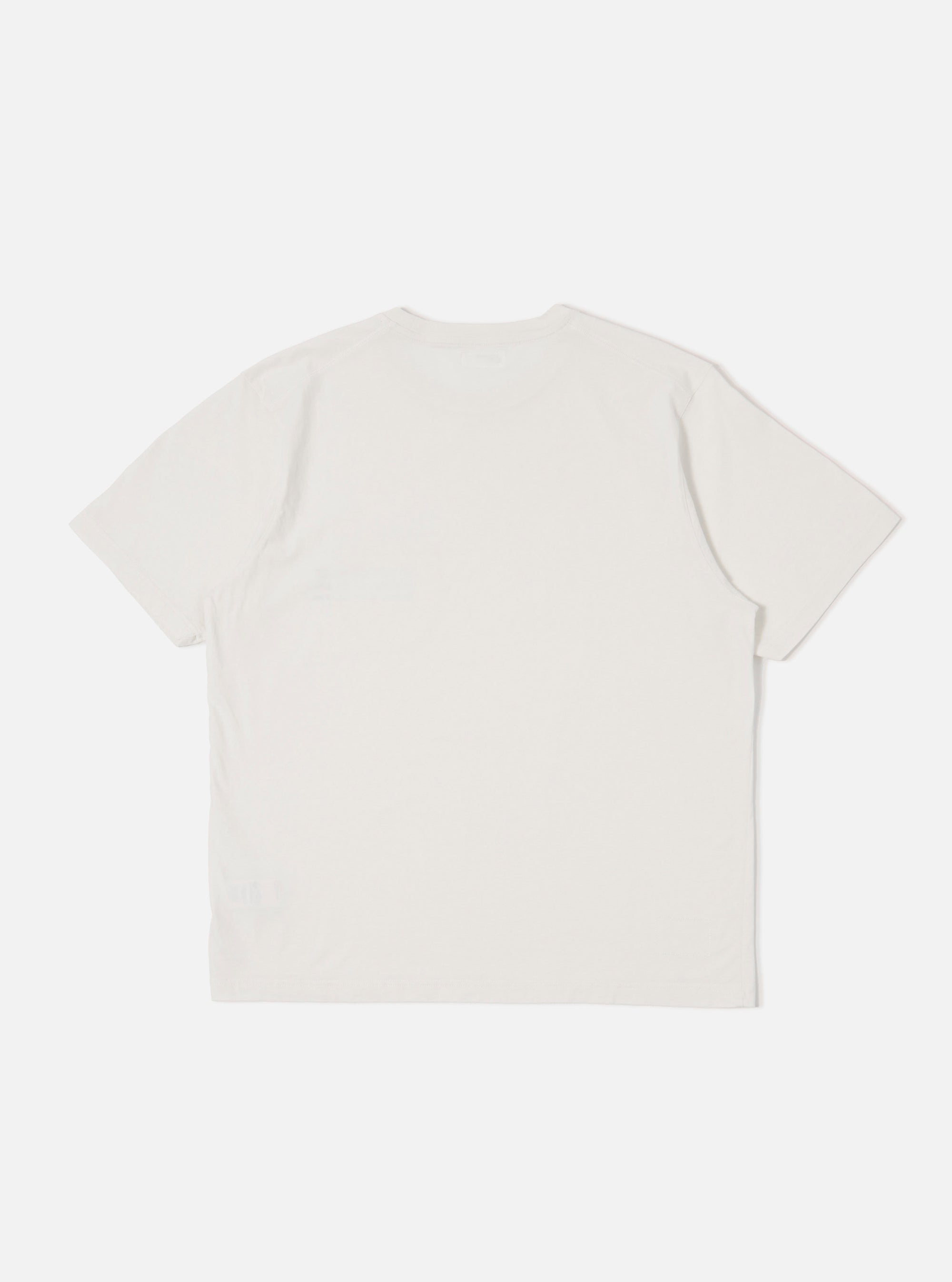 The Ecru Organic Jersey Print Pocket Tee is shown from the back as a flat lay against a plain white background. The image highlights the clean construction, straight hem, and the soft, off-white texture of the organic cotton jersey fabric.