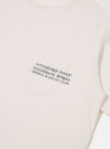 The Ecru Organic Jersey Print Pocket Tee is shown from the back as a flat lay against a plain white background. The image highlights the clean, simple construction of the t-shirt's rear panel and the soft, ecru-colored organic jersey fabric.