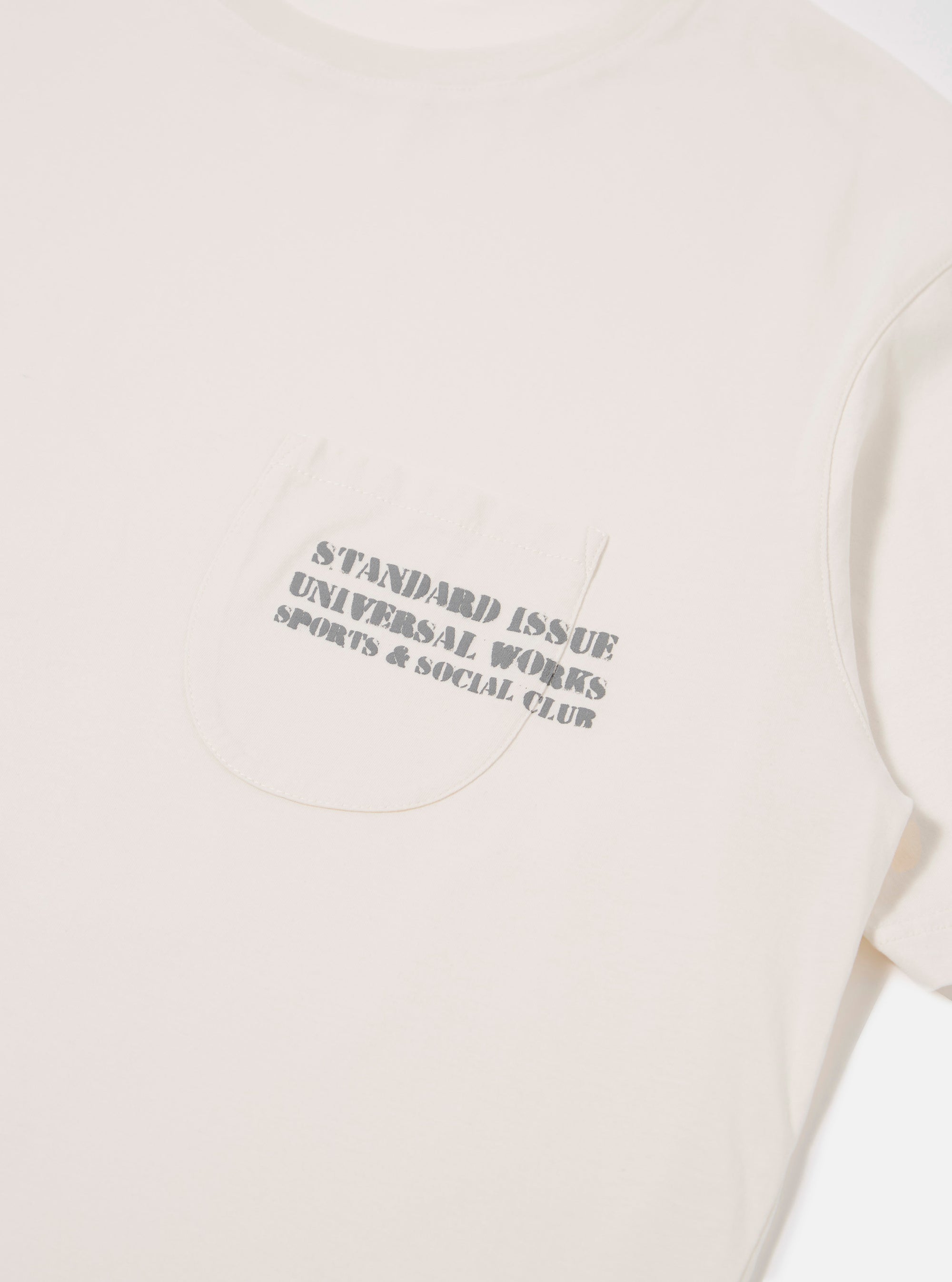 The Ecru Organic Jersey Print Pocket Tee is shown from the back as a flat lay against a plain white background. The image highlights the clean, simple construction of the t-shirt's rear panel and the soft, ecru-colored organic jersey fabric.