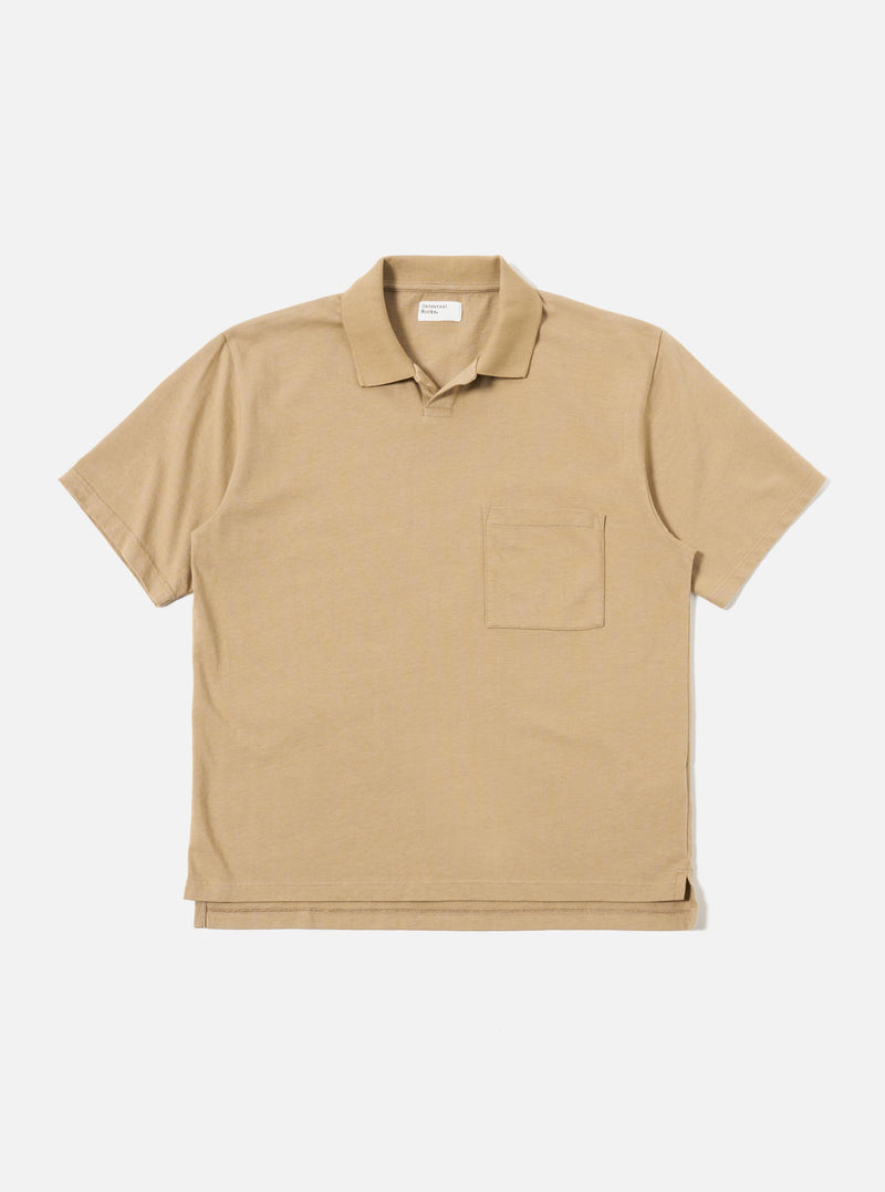The Sand Rugby Jersey Oversized Vacation Polo is shown as a flat lay against a white background. The polo features an oversized fit, a one-piece collar, a short placket with no fastening, and a single patch pocket on the left chest. The fabric is a heavy-weight rugby jersey in a neutral sand color.
