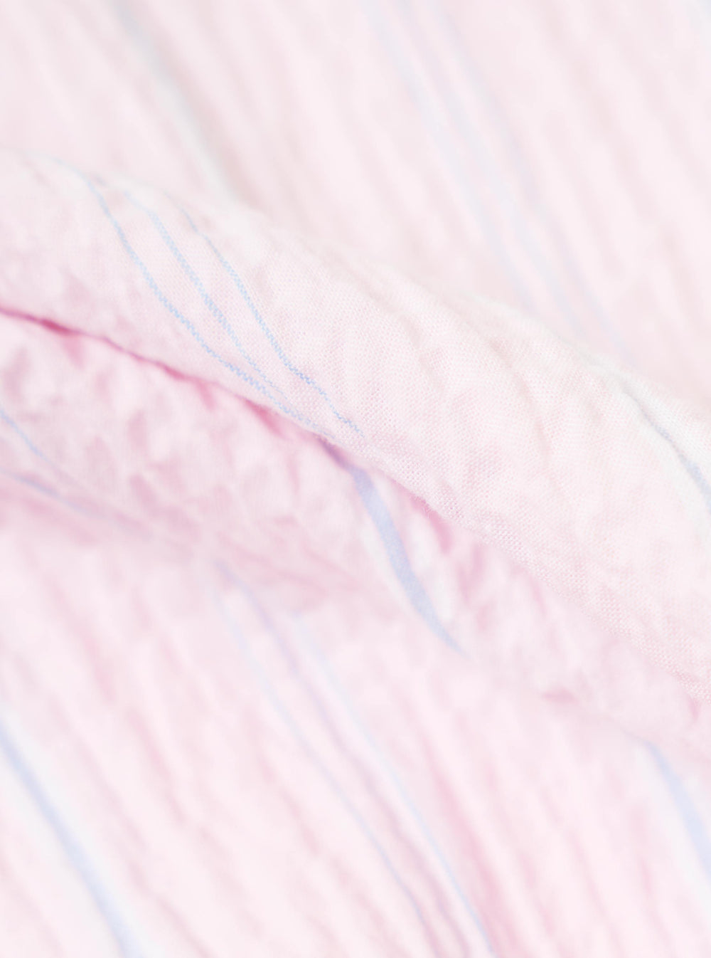 A close-up swatch image of the Pink Lily Stripe Road Shirt shows the fabric detail. The material features a pattern of vertical white and red stripes with a textured, woven appearance. The fabric is shown as a flat sample, and no model or mannequin is present.