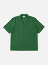 The Green Letts Cotton Road Shirt is presented as a flat lay against a plain white background. The shirt features a camp collar, a central button-down front, and a single patch pocket on the left chest. The short-sleeved garment is made from a solid green cotton fabric.
