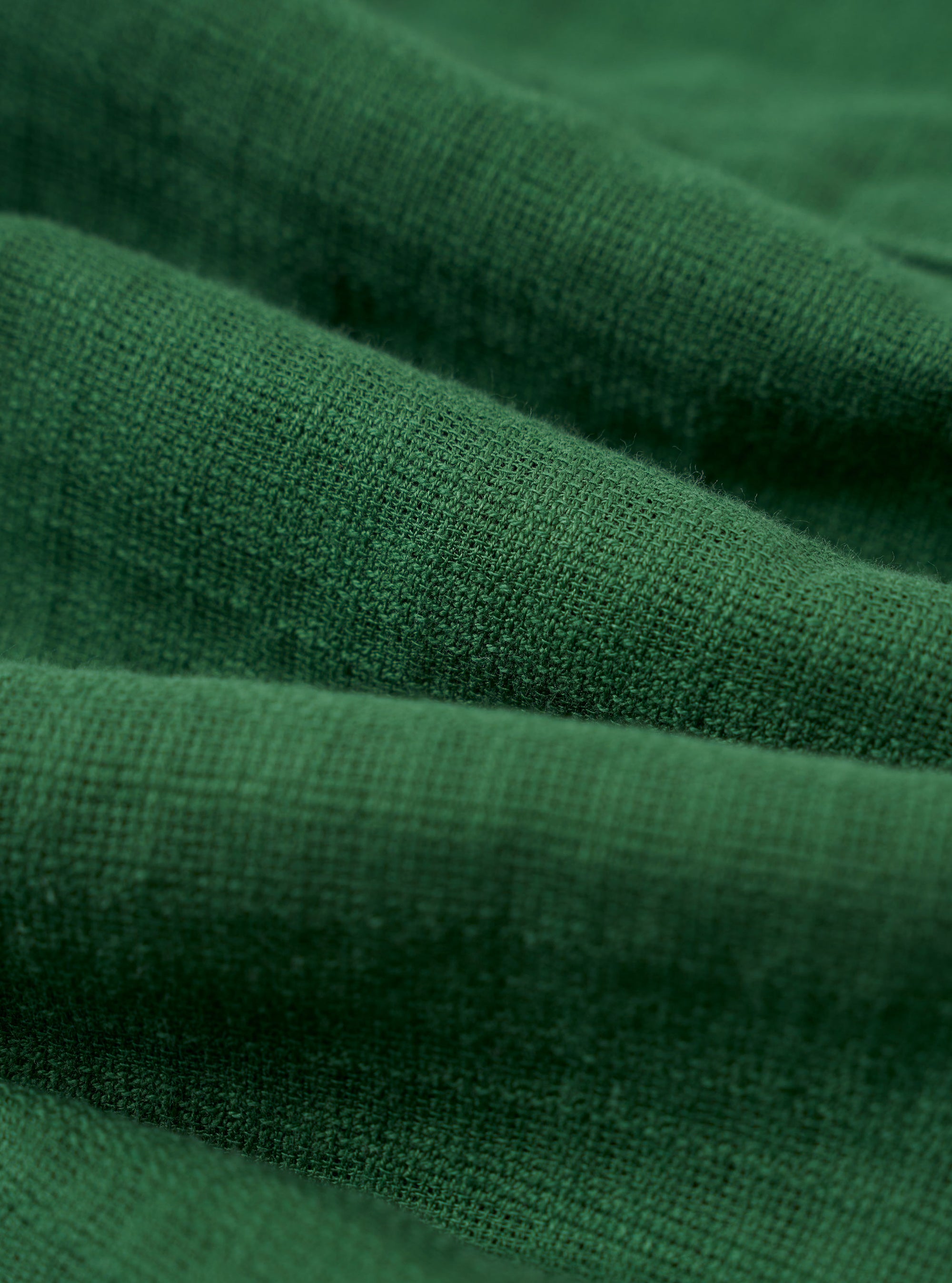 A close-up fabric swatch of the Green Letts Cotton Road Shirt highlights the olive green color and the fine, textured weave of the cotton material.