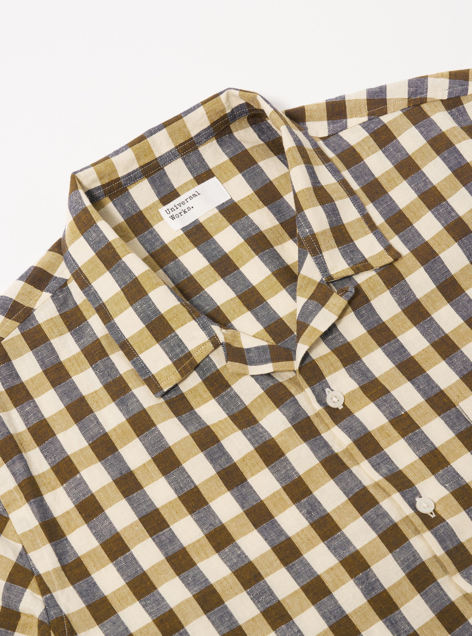 The Olive Aberdeen Lincot Road Shirt is shown from the back as a flat lay against a plain white background. The image highlights the shirt's construction, featuring a straight back yoke with a central box pleat and short sleeves. The fabric is a textured olive green cotton-linen blend with visible stitching.