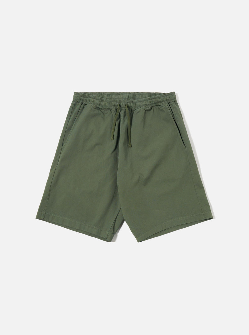 The Olive Kelly Cotton Simple Short is shown as a flat lay against a plain white background. The shorts feature an elasticated waistband with a matching olive green drawstring and two side pockets. The fabric is a solid olive green cotton with a smooth, matte finish.