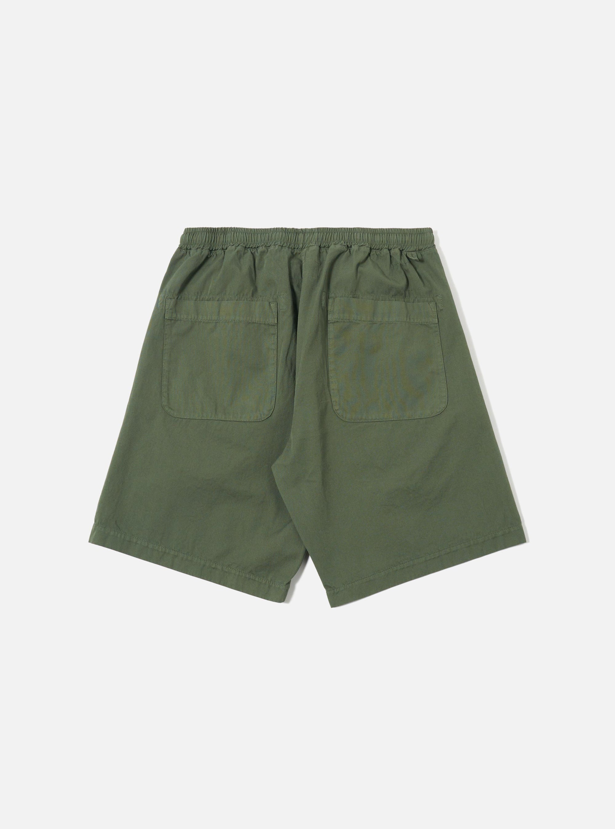 The Olive Kelly Cotton Simple Short is shown from a rear angle as a flat lay against a plain white background. The image highlights the two back patch pockets and the elasticated waistband of the olive green garment.