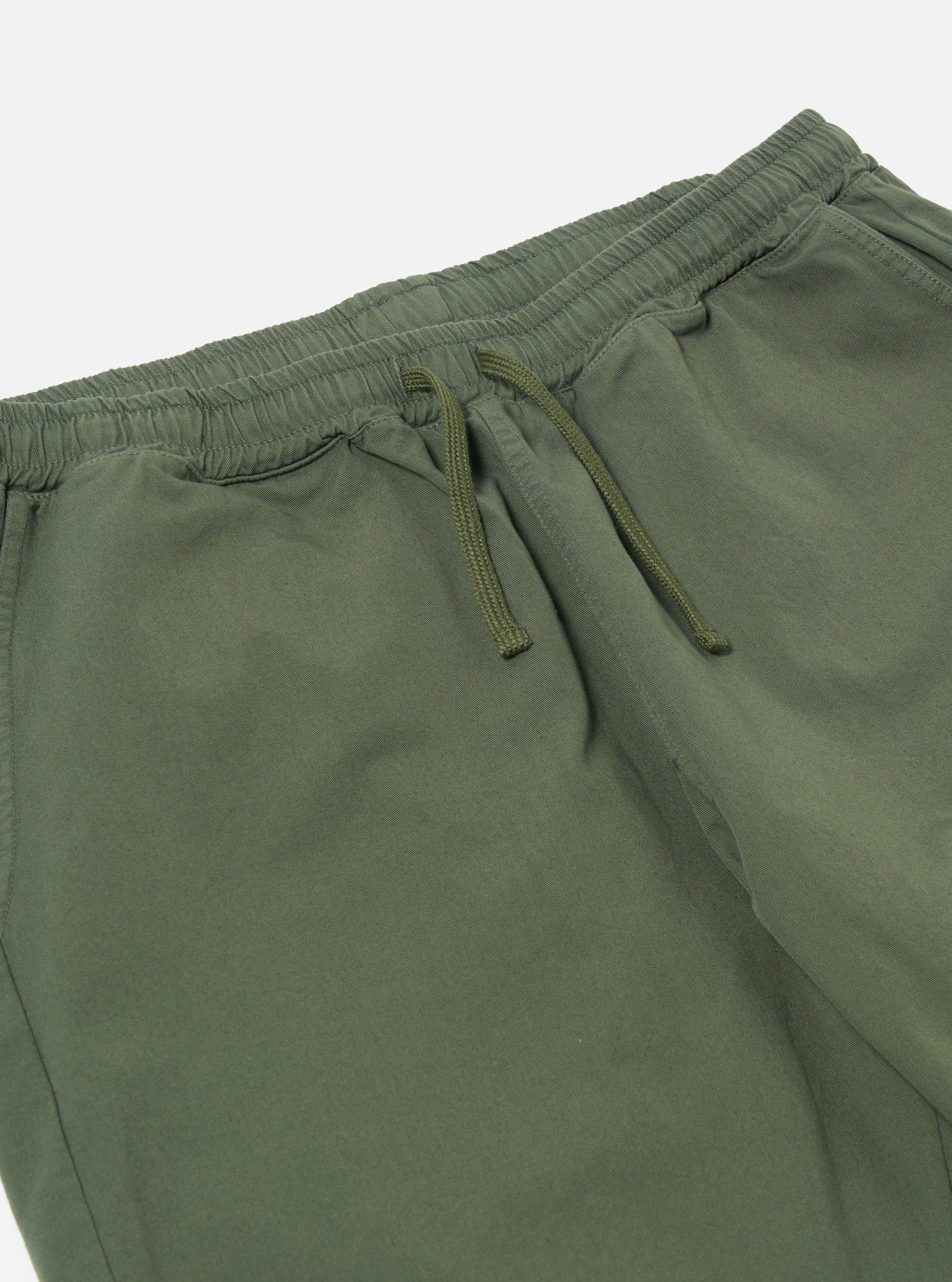 The Olive Kelly Cotton Simple Short is shown from the back as a flat lay against a plain white background. The image highlights the two rear patch pockets and the elasticated waistband of the olive green shorts.