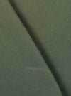 A close-up swatch image of the Olive Kelly Cotton Simple Short fabric highlights the olive green color and the subtle, woven texture of the kelly cotton material. The fabric fills the frame, providing a detailed view of the garment's color and construction.