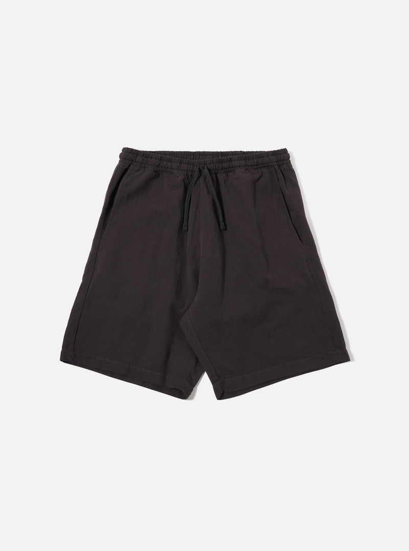 The Licorice Lyo Linen Mix Simple Short is presented as a flat lay against a plain white background. The shorts feature an elasticated waistband with a matching drawstring, slanted side pockets, and a clean, straight-leg silhouette. The fabric has a subtle, natural texture characteristic of a linen blend.