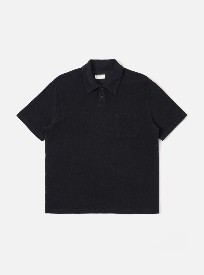 The Black Light Weight Terry Newlyn Polo is shown as a flat lay against a white background. The polo features a self-fabric collar, a two-button placket, and a single square chest pocket. The black fabric has a soft, textured terry cloth appearance with visible fine loops.
