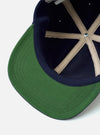 The Navy Canvas Baseball Hat is shown from a rear angle as a flat lay against a plain white background. The image highlights the back panels of the cap and the adjustable fabric strap with a metal buckle. The navy blue cotton canvas fabric has a clean, matte finish.