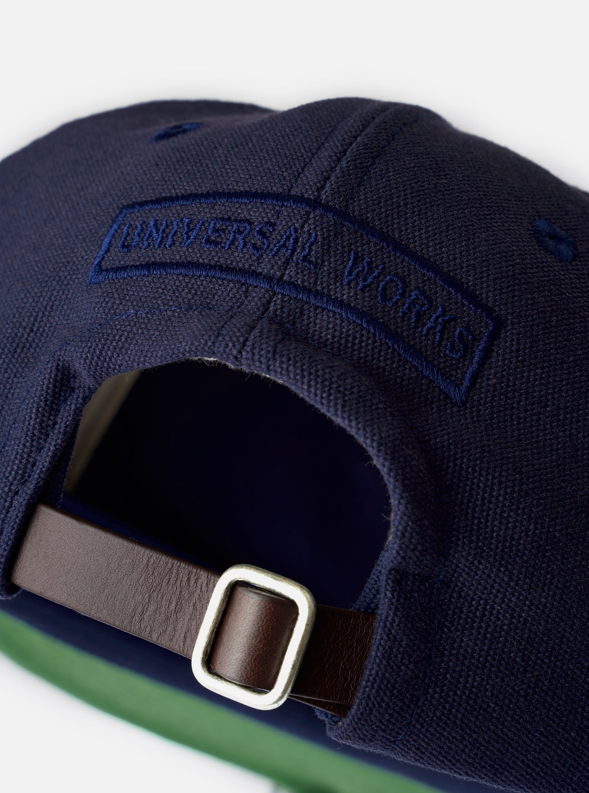 The Navy Canvas Baseball Hat is displayed as a flat lay against a plain white background. The hat features a classic six-panel construction, a curved brim, and an adjustable strap at the back. The navy blue canvas fabric has a visible, sturdy texture.