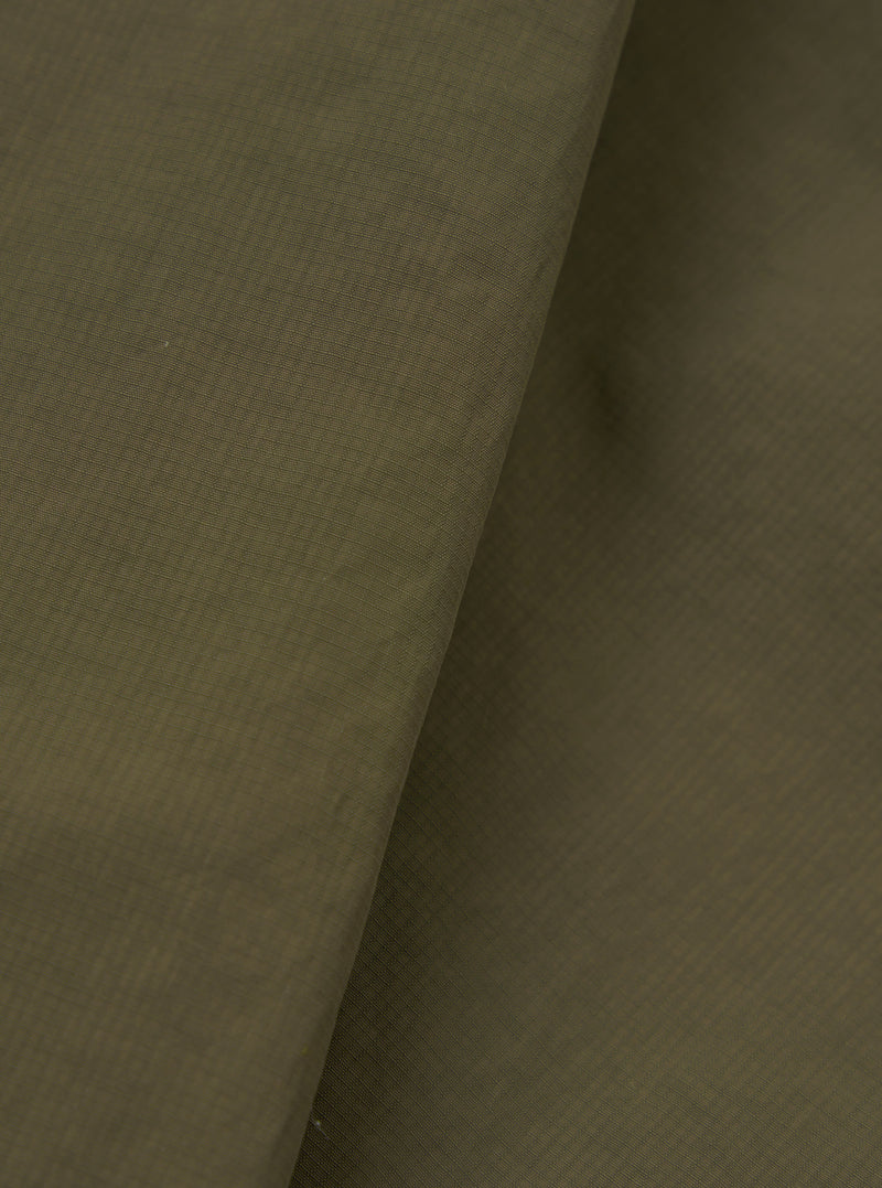 A close-up fabric swatch image of the Olive WR Recycled Nylon Peak Parka against a neutral studio background. The shot emphasizes the rich olive green colour, smooth weave, and water-resistant nylon texture.