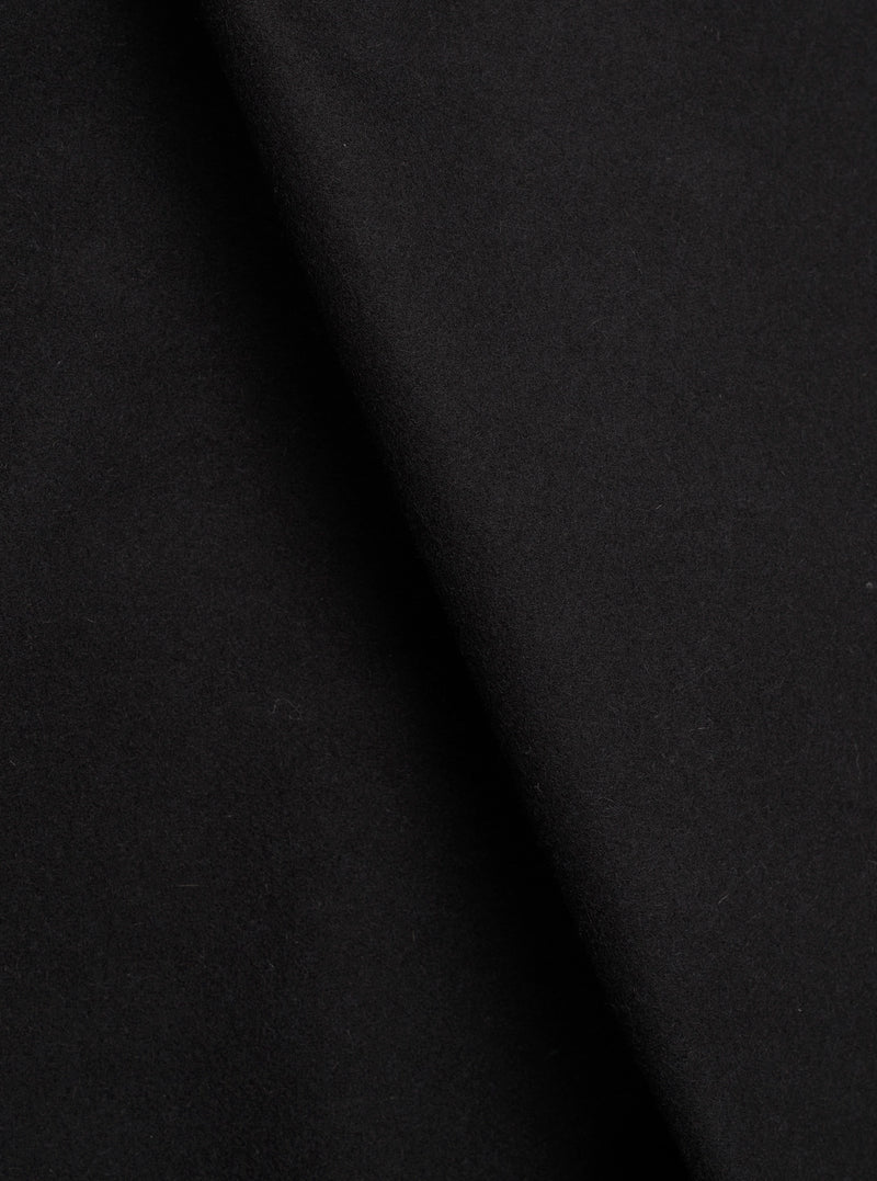 Close-up of the black Mowbray Heavy Duty Jacket fabric, showing a soft, dense wool-like texture with a matte finish. The material is draped with gentle folds creating subtle shadow variation across the surface. No garment details or background are visible in this tight fabric shot.