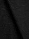 Close-up of the black Mowbray Heavy Duty Jacket fabric, showing a soft, dense wool-like texture with a matte finish. The material is draped with gentle folds creating subtle shadow variation across the surface. No garment details or background are visible in this tight fabric shot.