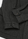 Close-up flat lay of the grey marl Mowbray heavy duty jacket on a white surface. The brushed wool fabric has a dense, textured marl finish. Four-hole black buttons are visible on two button cuffs and along the front placket. A patch pocket is visible at the lower left.