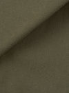 Close-up of olive brushed moleskin fabric used in the Franck Jacket. The folded edge runs diagonally across the frame, showing the soft, lightly napped texture of the outer face against the smoother reverse side. Plain solid colour with no pattern or surface detailing visible.