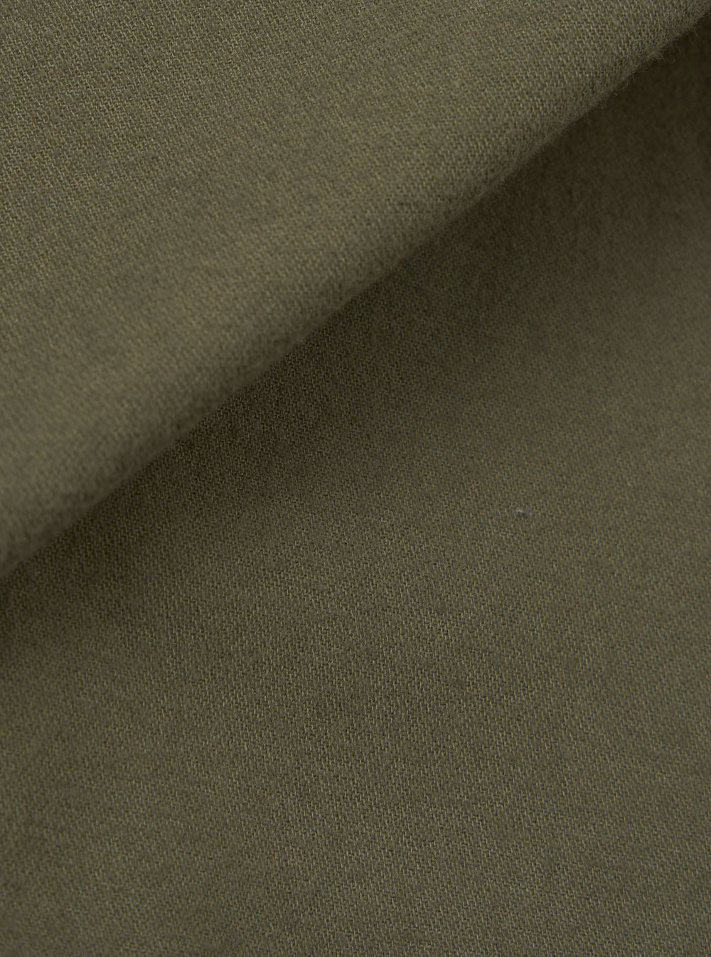 Close-up of olive brushed moleskin fabric used in the Franck Jacket. The folded edge runs diagonally across the frame, showing the soft, lightly napped texture of the outer face against the smoother reverse side. Plain solid colour with no pattern or surface detailing visible.