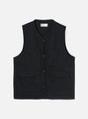 Black brushed moleskin gilet laid flat on a light grey studio backdrop. V-neckline with a Universal Works woven label at the back neck visible. Four button placket down the centre front with dark tonal buttons. Two chest patch pockets and two lower flap pockets. Sleeveless with armhole binding. Plain weave with a soft brushed texture.