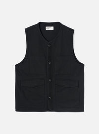 Black brushed moleskin gilet laid flat on a light grey studio backdrop. V-neckline with a Universal Works woven label at the back neck visible. Four button placket down the centre front with dark tonal buttons. Two chest patch pockets and two lower flap pockets. Sleeveless with armhole binding. Plain weave with a soft brushed texture.